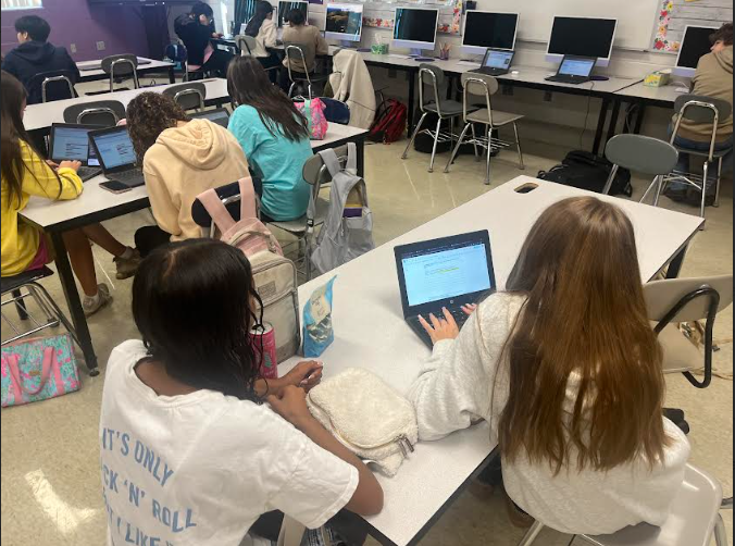 Mia Ward and Ameelah McFarland work on their chromebook to complete their article