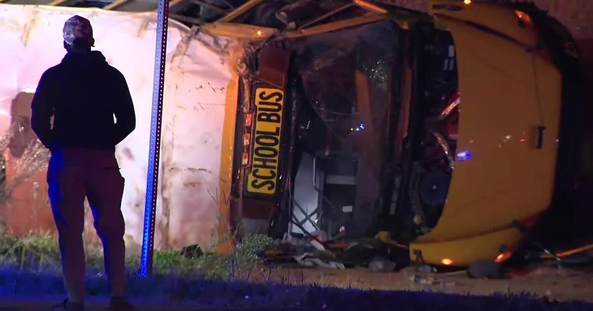 Overturned school bus at a Rockdale County intersection with emergency crews nearby